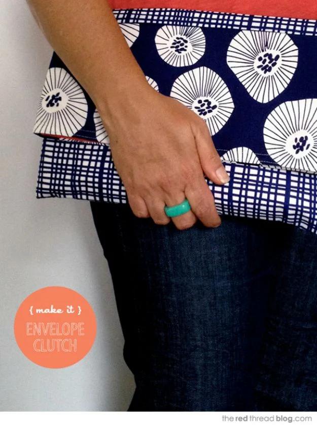 An envelope clutch in mustard cotton, flap folded down over a magnetic snap, with a contrast lining showing.