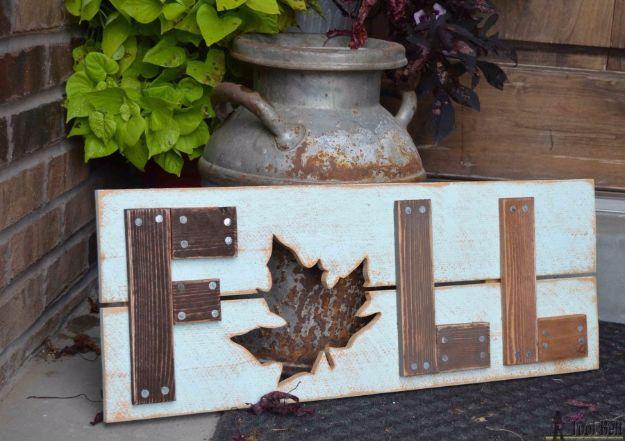 Wooden fall sign on pale blue distressed planks with rough wood letters and a cut out maple leaf for the A