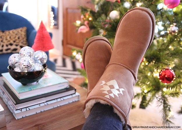 Personalized Uggs, tan sheepskin boots with a small gold geometric motif painted on the outer side, by a Christmas tree