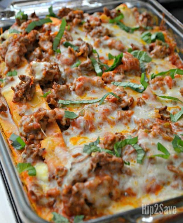 Low carb keto lasagna baked in a metal pan with browned cheese, meat sauce and fresh basil across the top