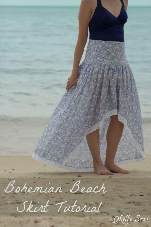 Woman on a sandy beach in a blue printed high low voile skirt and navy top, under a typeset script title