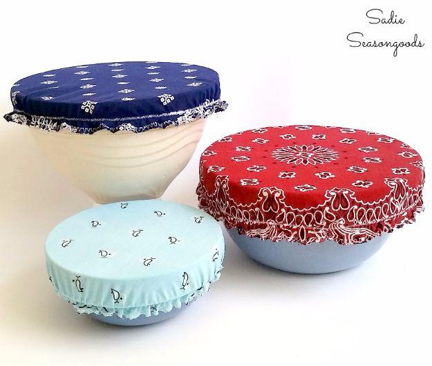 Three bandana bowl covers in navy, red and aqua stretched over mixing bowls on a plain white surface background