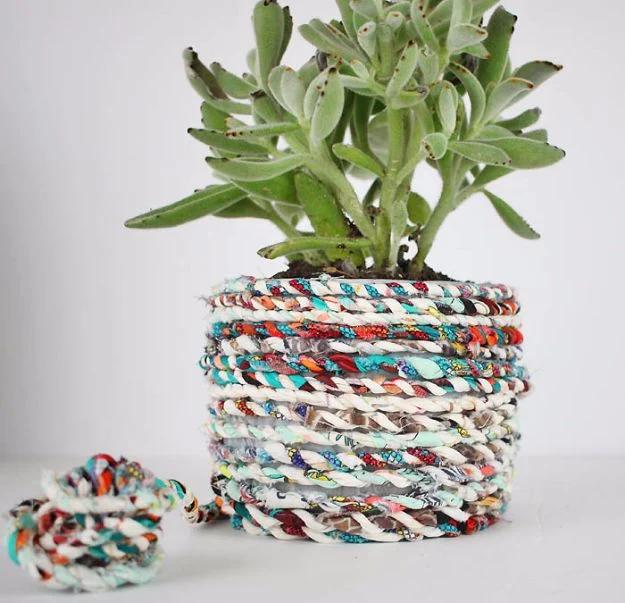 Quilting scraps fabric twine coiled beside a small pot wrapped in the same multicolored twisted cord with a succulent