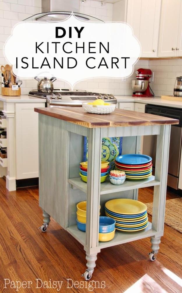 Grey green kitchen island cart on casters with a walnut top and two shelves stacked with bright yellow and blue dishes