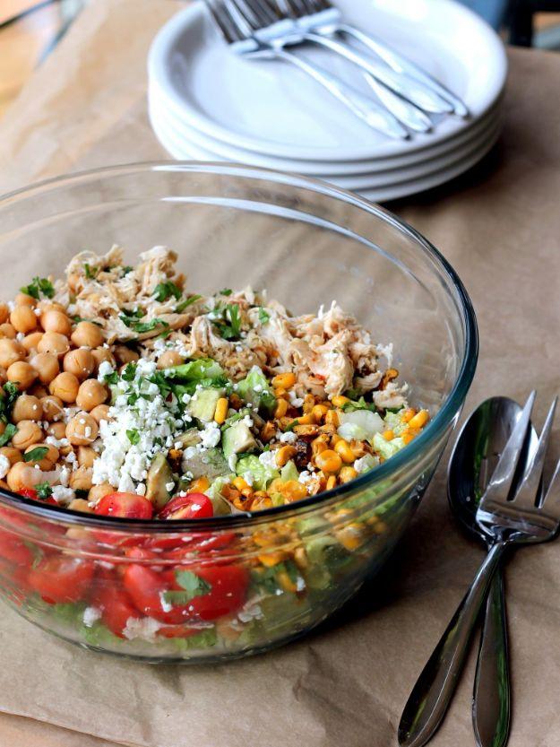 Healthy chicken chickpea chopped salad in a clear glass bowl with chickpeas, corn, tomatoes and avocado