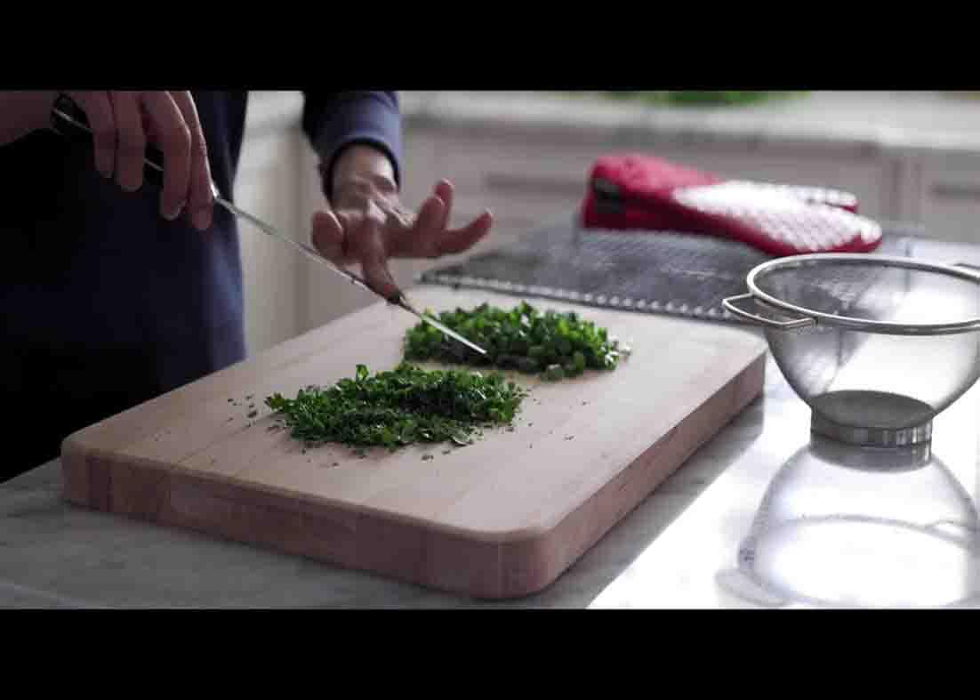 Chopping the green onion and parsley for the sweet potato hash recipe
