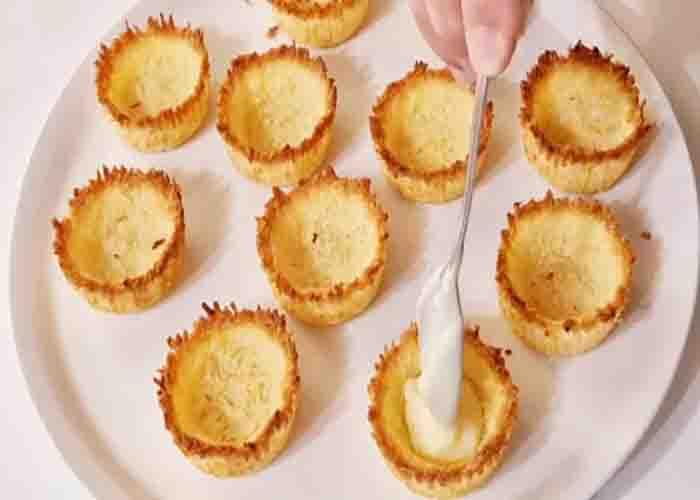 Adding the filling to the coconut tartlets