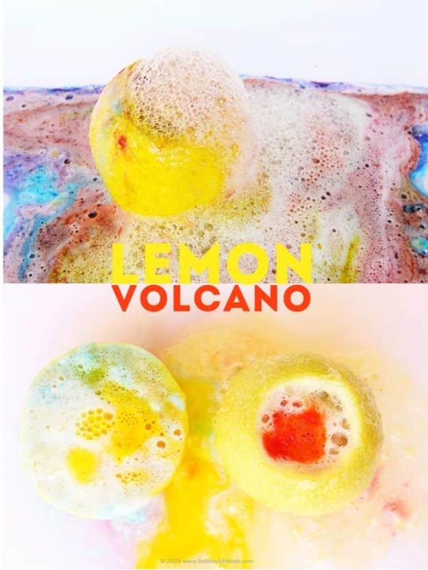 Lemon volcano, a whole lemon erupting with pale foam onto a white tray streaked with blue and pink, above two halved lemons