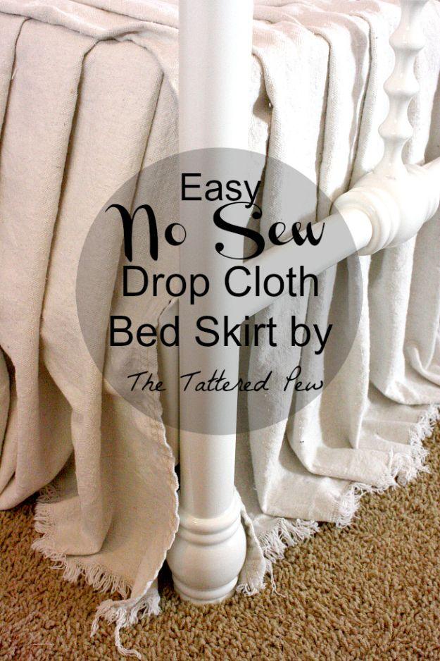 Natural canvas drop cloth bed skirt gathered around the base of a white wooden bed on a bedroom floor