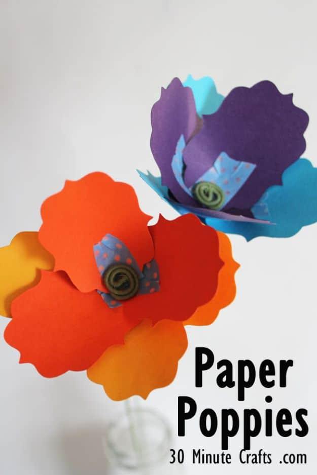 Orange and purple paper poppies made from die cut cardstock petals with green coiled floral wire centers
