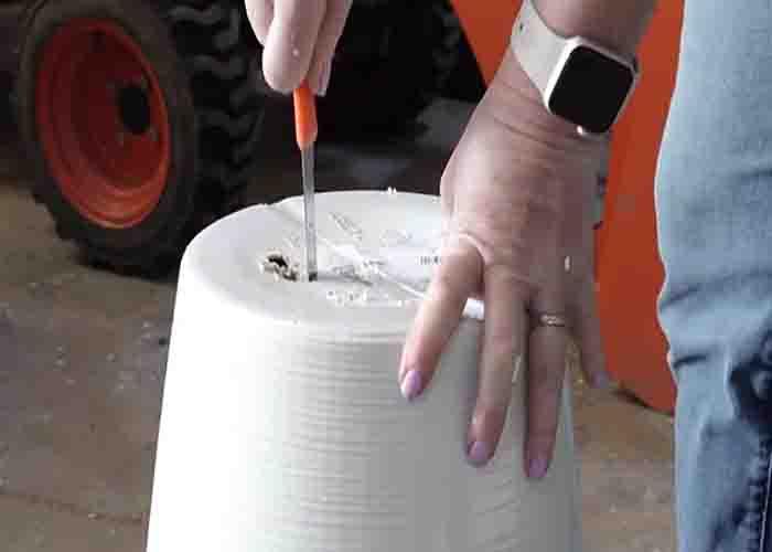Cutting a hole to the bottom of the planter to make the DIY solar water fountain
