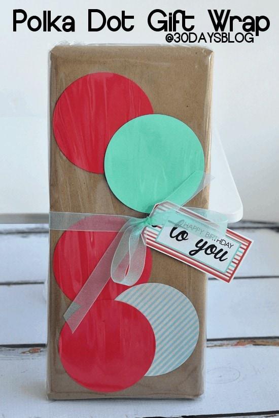 A kraft paper parcel covered in red, mint and striped punched paper circles held on by clear cellophane