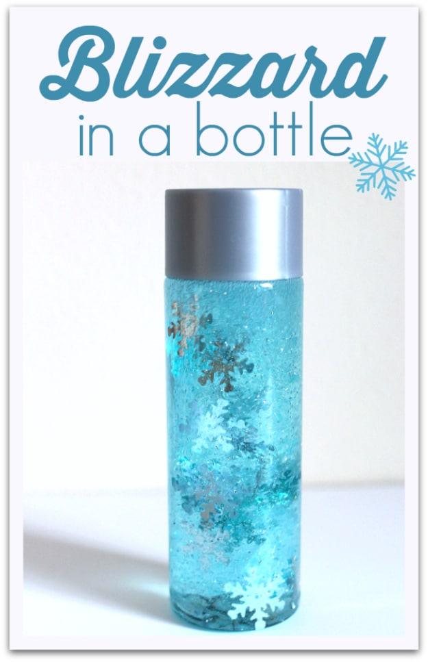 Tall clear bottle of blue glitter water with silver and white snowflakes suspended inside, typeset graphic