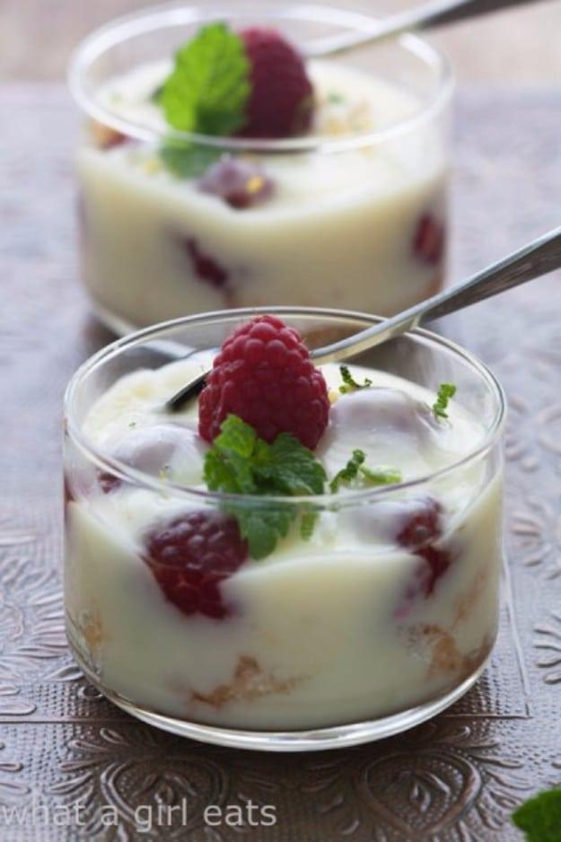 Fresh raspberry posset in small glasses topped with berries and mint, a three ingredient make ahead dessert