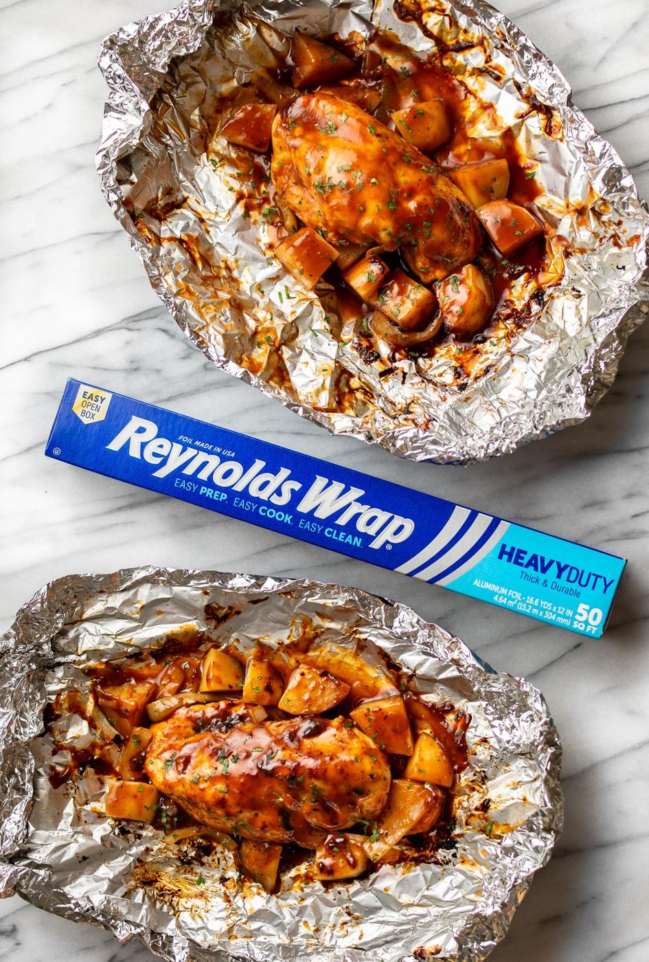 BBQ chicken foil packet opened to show saucy chicken breast with diced Russet potatoes and sliced onion