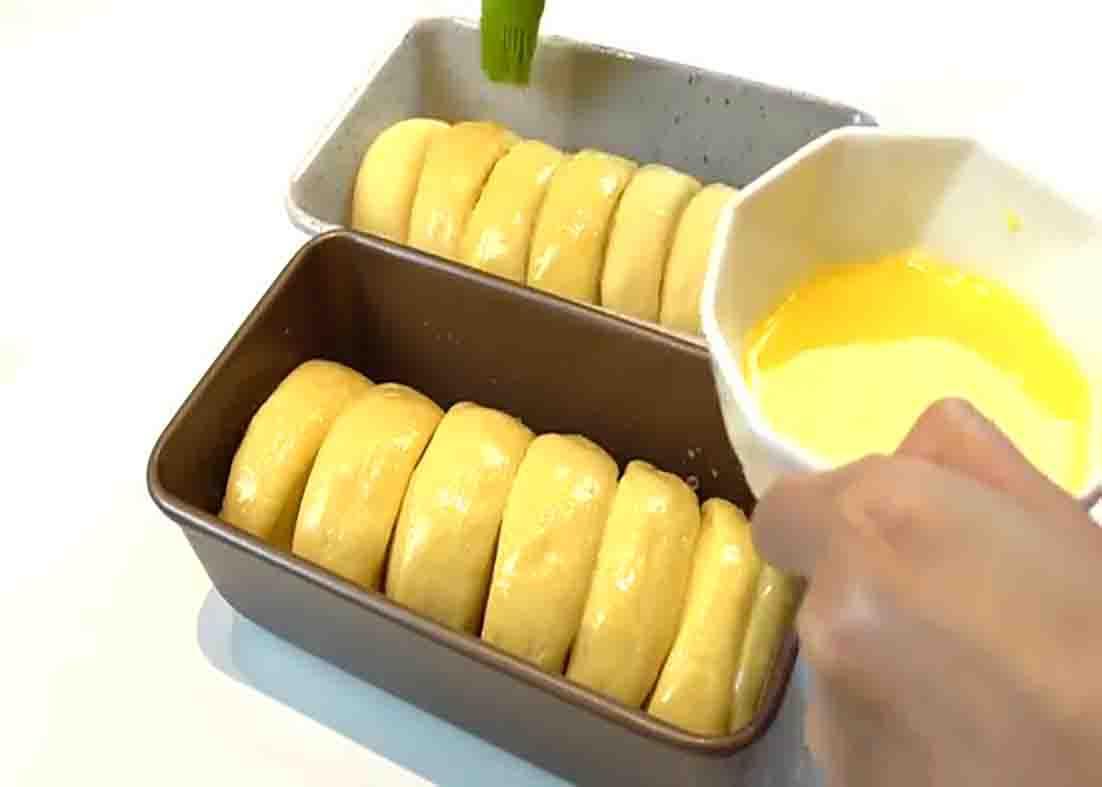 Brushing the top of the bread with egg wash