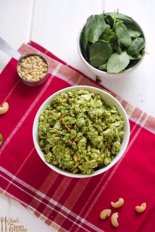 Crock pot pesto chicken salad made with shredded chicken, basil spinach pesto and pine nuts in a bowl