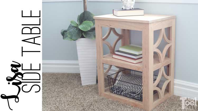 Finished light wood side table with two shelves and decorative quatrefoil cutout side panels, styled in a room
