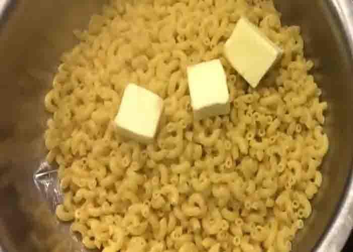 Adding the butter to the mac n cheese