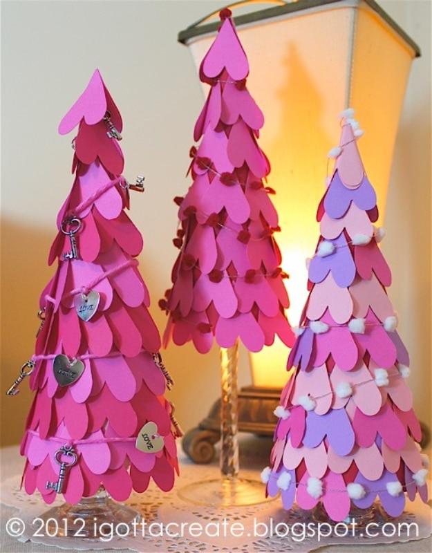 Cone shaped Valentine tree covered in layered pink and red fabric hearts sitting on a decorated table