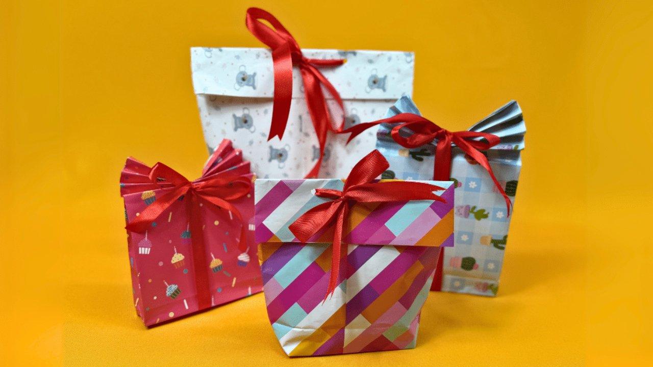 DIY gift bag made from wrapping paper with a glued flat bottom, accordion pleated top and a tied ribbon