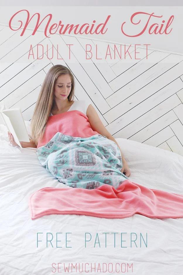 A teal fleece mermaid tail blanket in the adult size, folded over the arm of a wooden chair by a window.