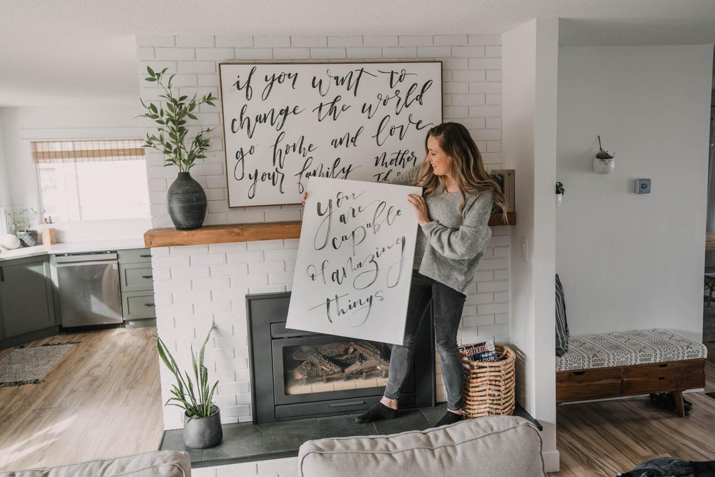 DIY bedroom wall decor, a large hand brush lettered canvas painted in black acrylic reading you are capable of amazing things