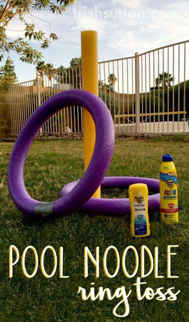 Pool noodle ring toss with a purple noodle ring and a yellow noodle target staked into a sunny backyard lawn