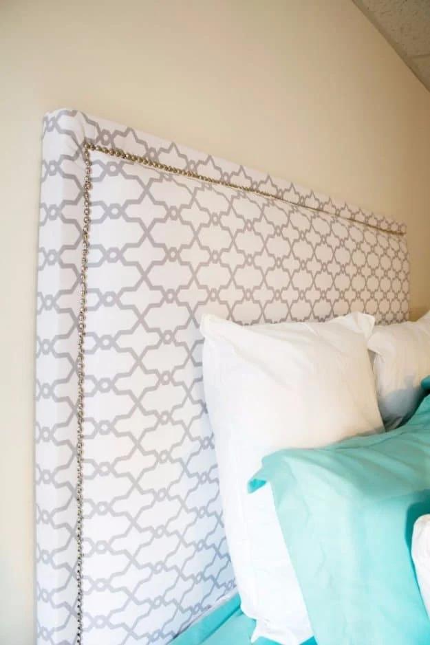 DIY fabric headboard, a gray and white trellis print upholstered headboard with nailhead trim over turquoise bedding