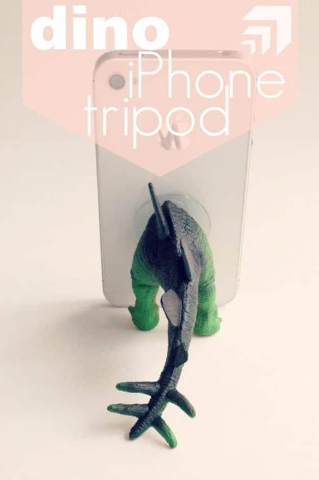 A toy dinosaur turned into a phone stand with a suction cup holding a smartphone, a fun DIY gift for him