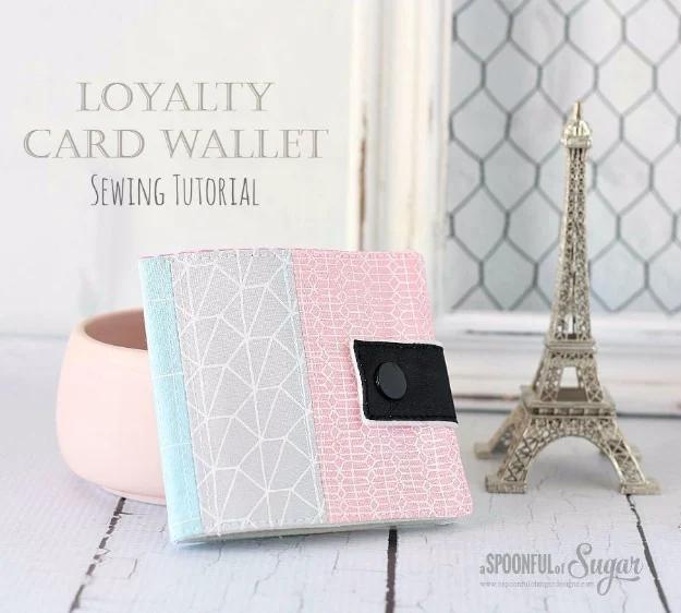 A slim card wallet in printed cotton opened to show its interfaced card slots, sewn from a fat quarter and a snap
