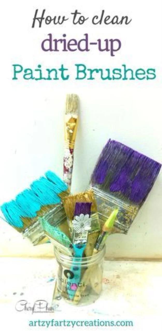 Painting hack for brushes, paint brushes crusted with dried teal and purple acrylic standing in a glass jar