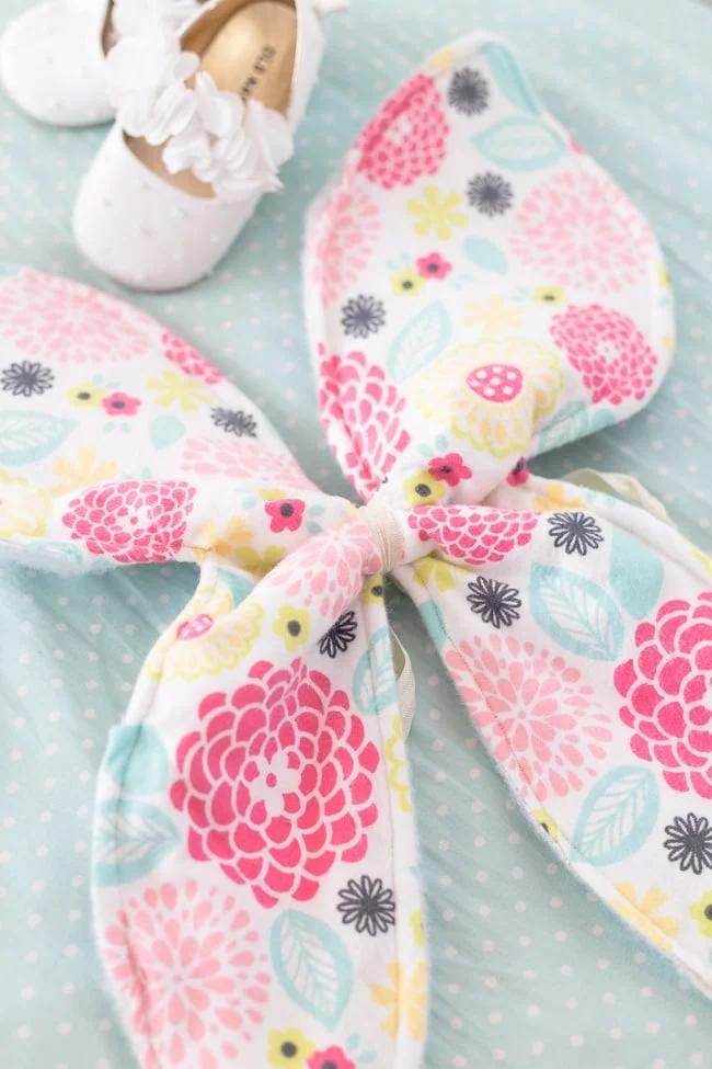 Floral fabric butterfly wings laid flat beside white shoes, showing the finished sewn dress-up costume pieces