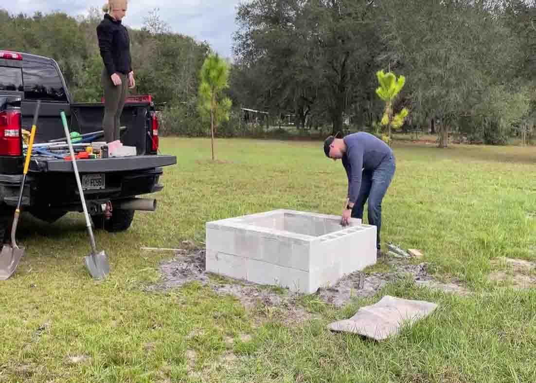 Putting the cinder block caps to finish off the fire pit