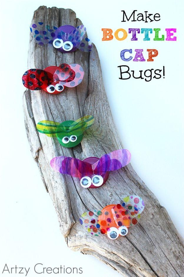 Six bottle cap bugs with Sharpie colored transparency wings and googly eyes, arranged on a piece of driftwood