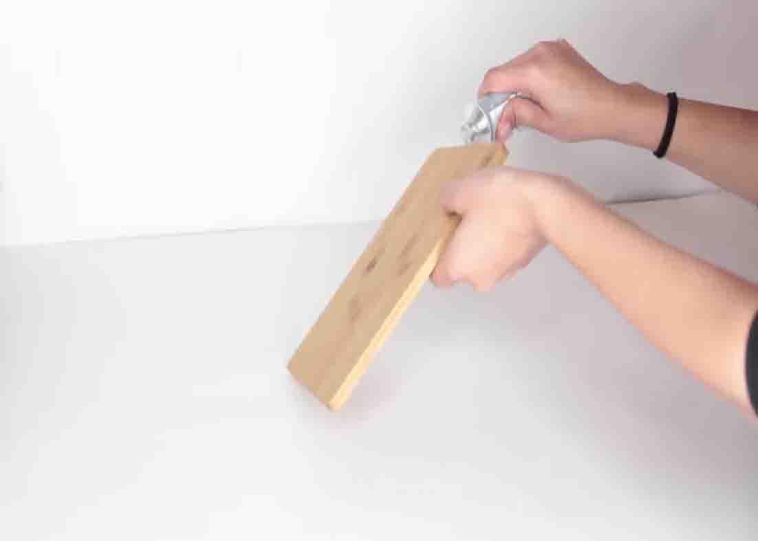 Putting hot glue to both sides of the cutting board to make the cube organizer