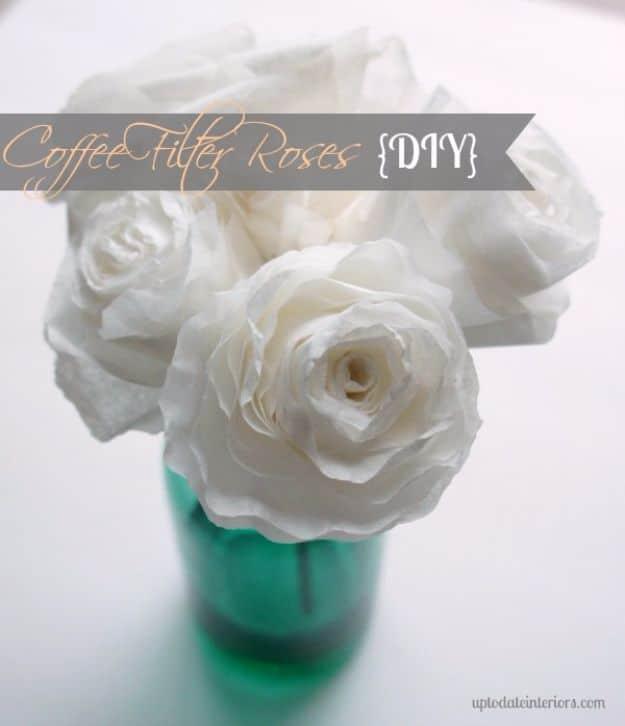 White coffee filter roses arranged in a green cup on a white surface, under a typeset Coffee Filter Roses banner