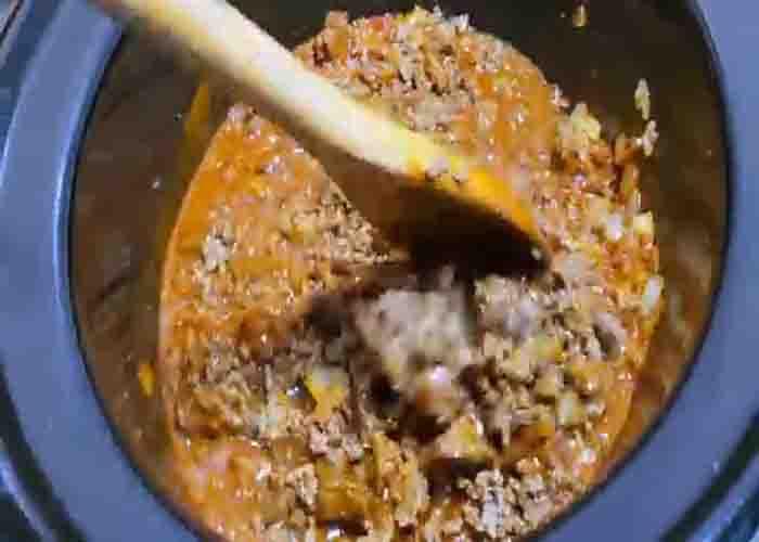 Adding all the ingredients in the crockpot for the chili recipe