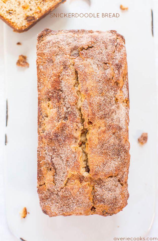 Snickerdoodle bread loaf with a cracked cinnamon sugar crust sitting uncut on a white serving platter