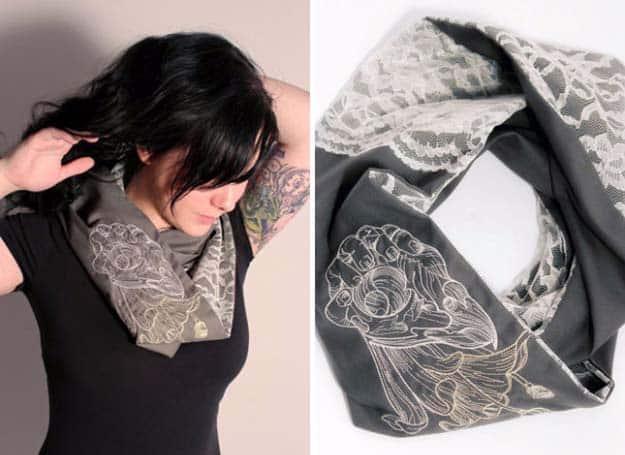 Lace infinity scarf, a dark gray loop scarf with a cream lace panel and a large embroidered figure, worn