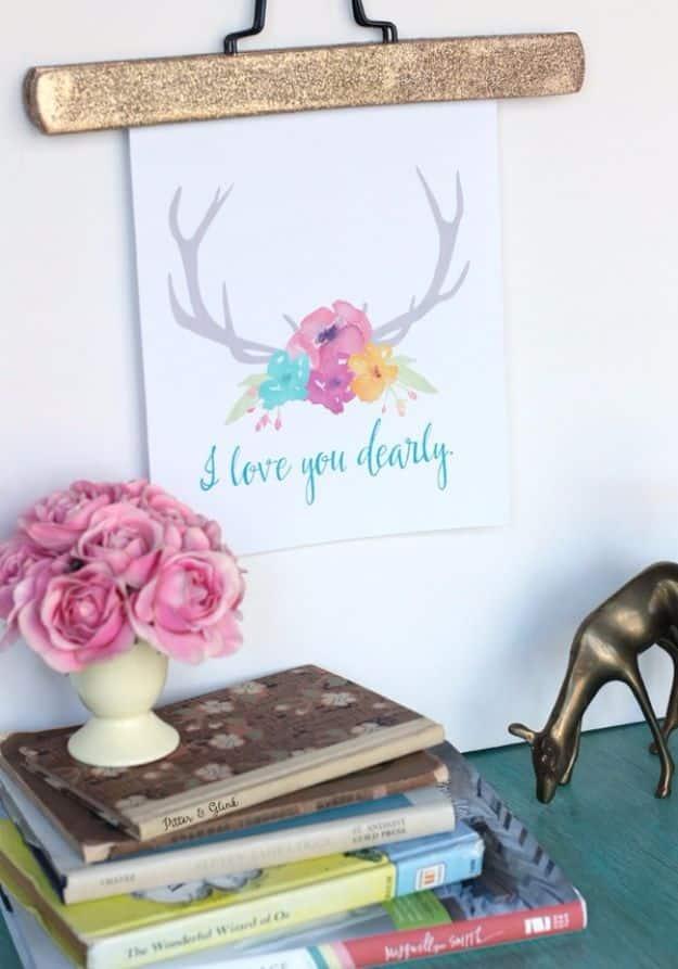 Free I love you dearly printable, grey deer antlers with watercolor flowers at the centre and teal script below, hung above