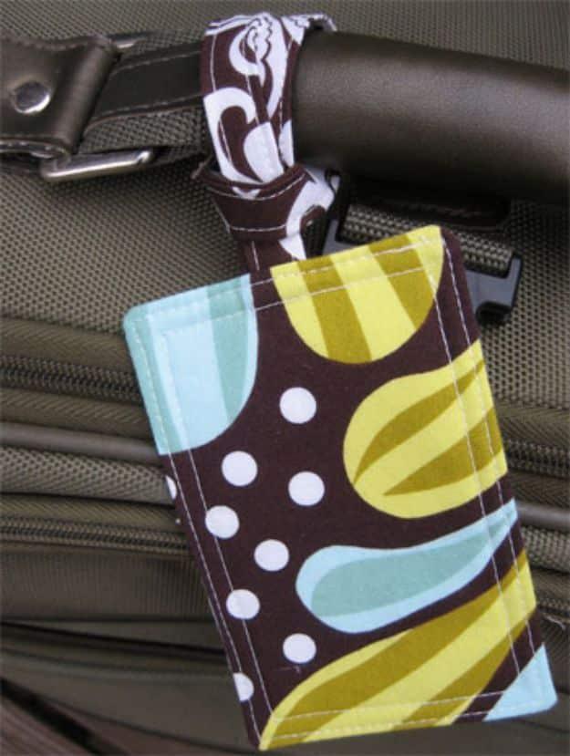 Fabric luggage tag in a brown, olive and aqua mod print, its fabric strap looped around a suitcase handle