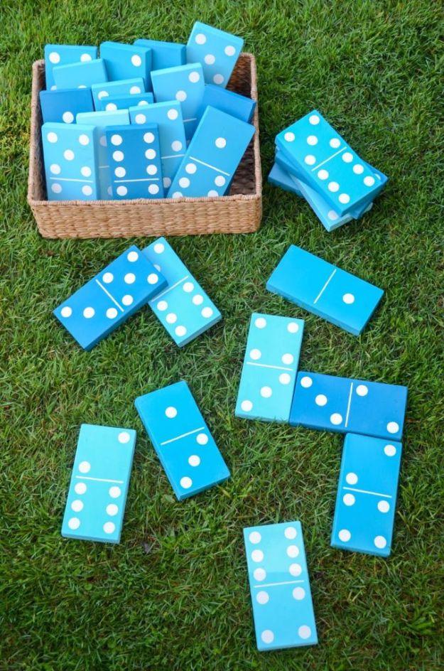 DIY lawn dominoes painted in blue and teal with white dots, a giant backyard game laid out on green grass