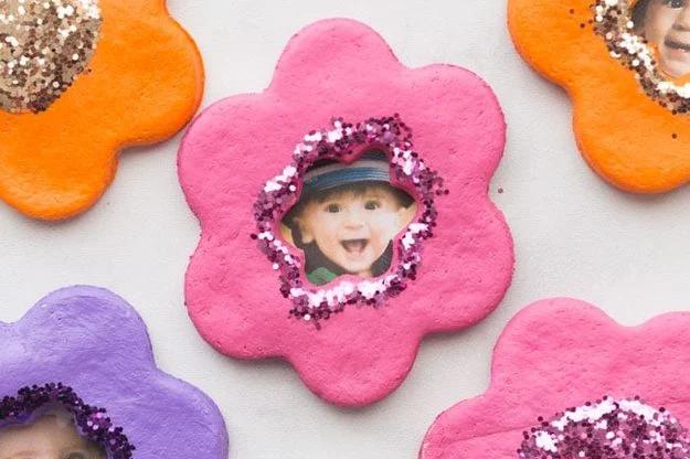 Salt dough flower shaped photo magnets glittered around a small photo center, a personalized craft to sell