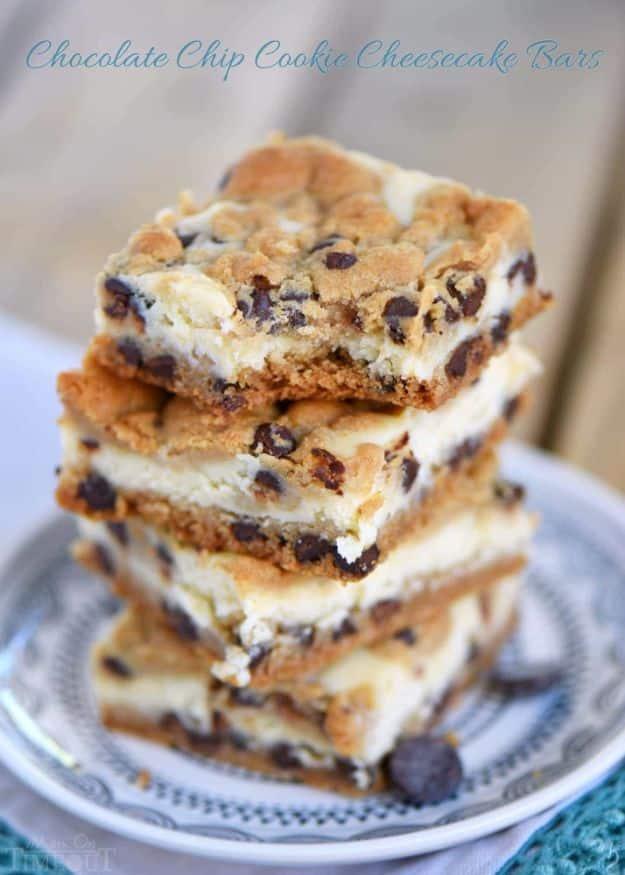 Chocolate chip cookie cheesecake bars stacked on a blue patterned plate, cheesecake layer showing in the middle