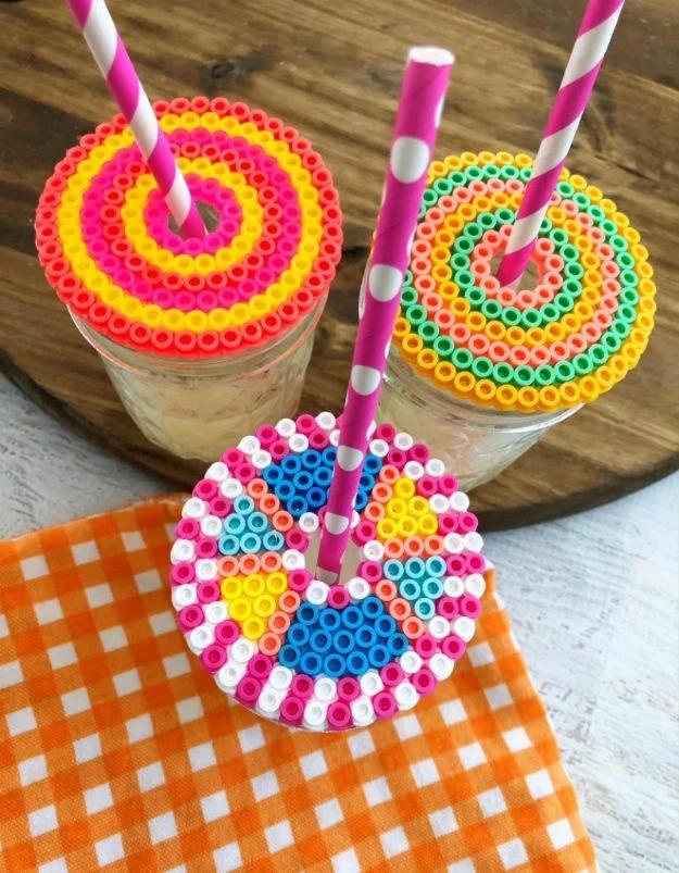 Perler bead drink topper, two beaded circles in pink and yellow sitting on mason jars with paper straws through