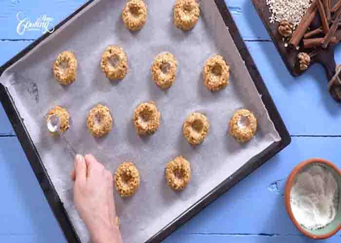 Making the indentation on each carrot cake thumbprint cookies