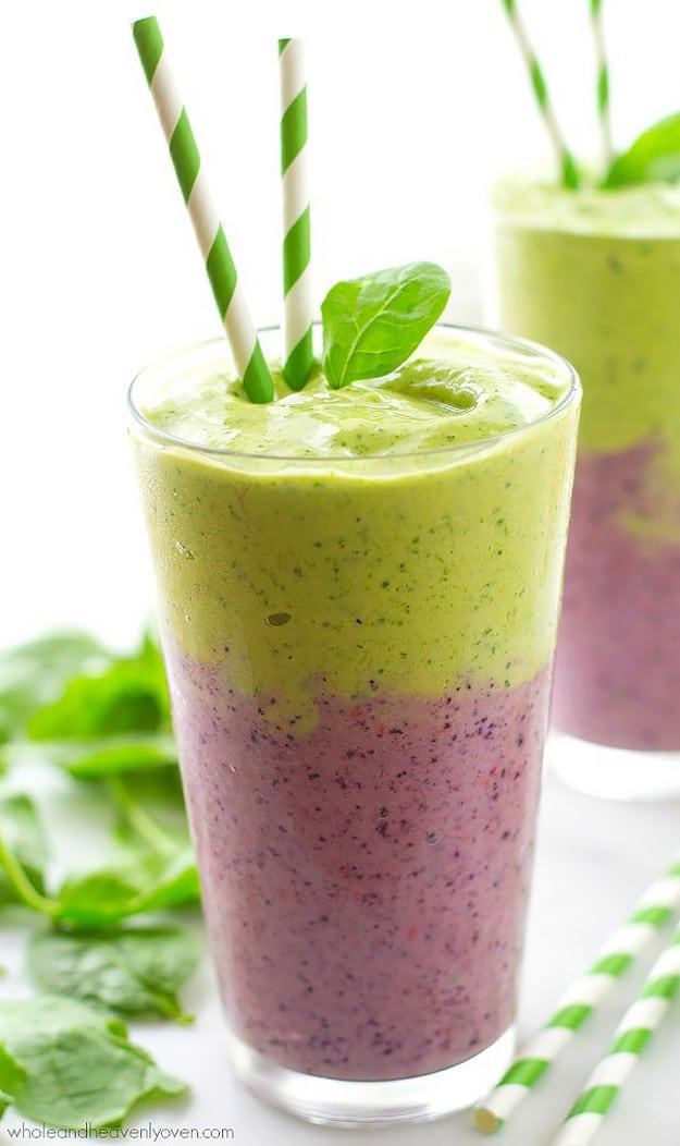 Mixed berry and green power smoothie poured in two distinct layers, berry below and spinach layer on top