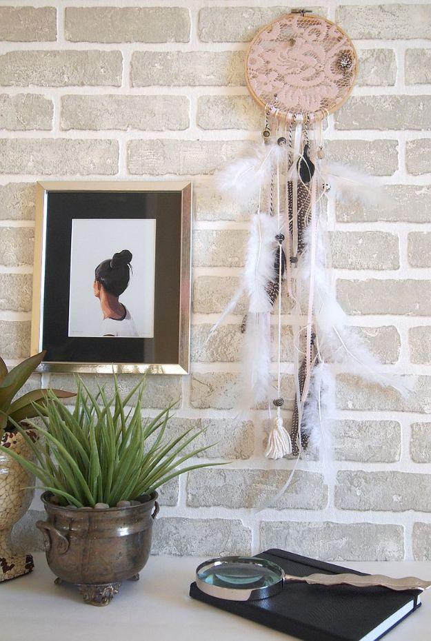 Lace dreamcatcher with feathers and beads hung on a white brick wall, an easy beginner DIY home decor idea