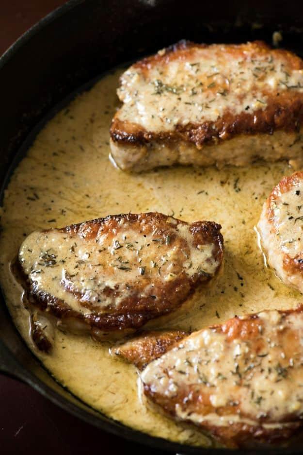 Lemon thyme chops resting in a creamy lemon and white wine pan sauce with thyme and sliced green onions
